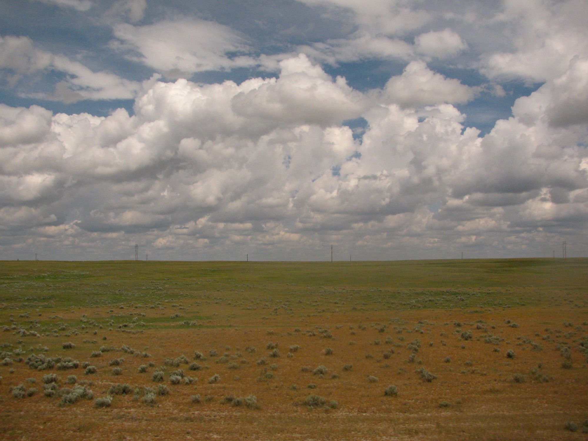 View of North Dakota plains with billowing clouds from window of Amtrak Empire Builder